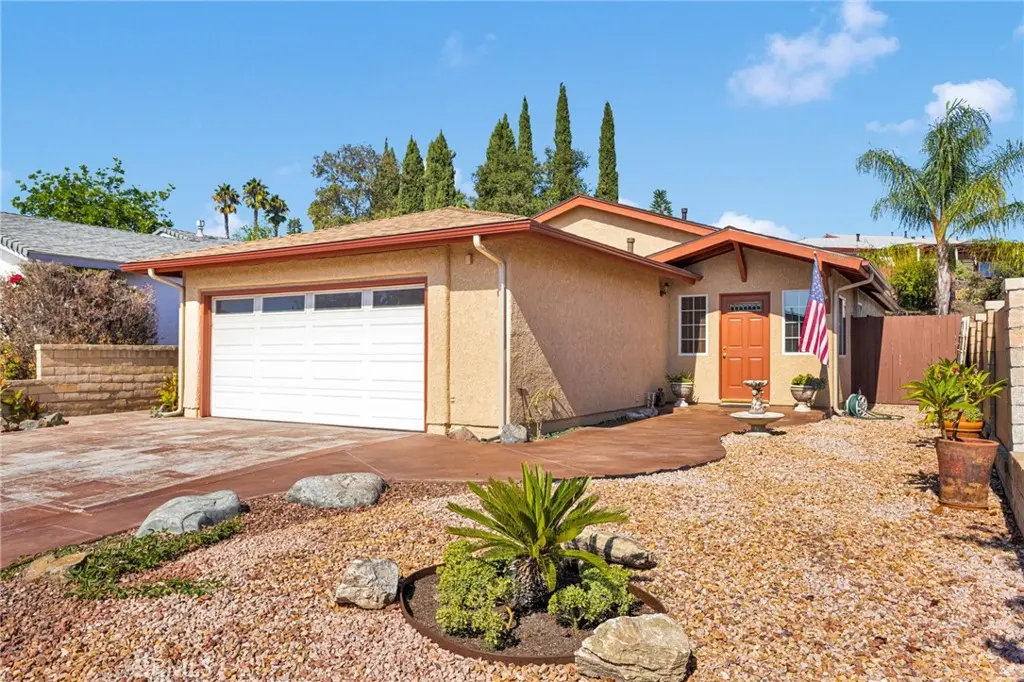 Front exterior with drought-tolerant landscaping and pergola entrance